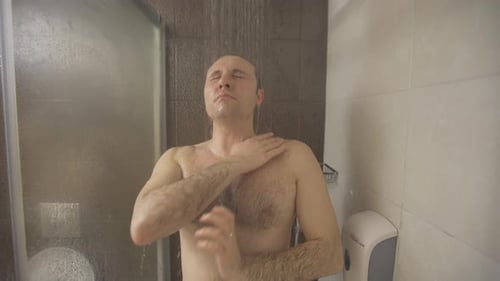 L'homme prend une douche dans la salle de bains.