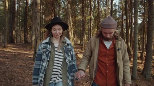 Couple Holding Hands and Walking in Forest