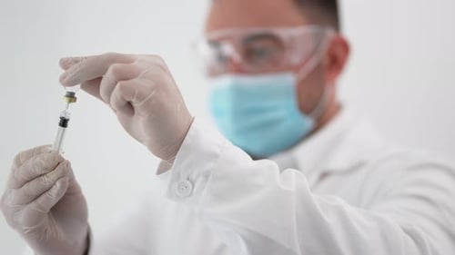 Scientist Fills Needle with Medicine from Bottle