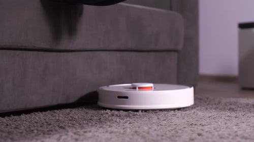 Woman Relaxing as Robot Vacuum Cleans Carpet