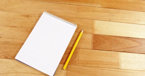 Pencil and Notebook on Wood