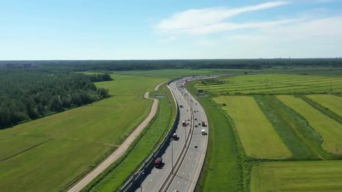 Asphalt Speedway with Cars Through Green Field. Aerial View From Drone