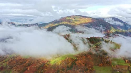 Flight Through Blue Sky with Clouds Over Mountain