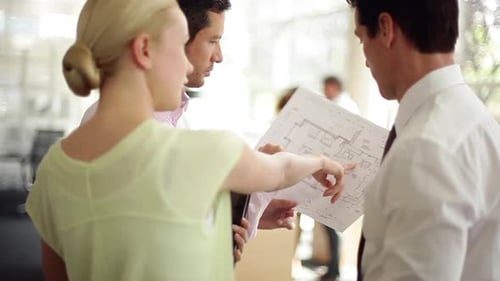 Architects Reviewing Plans in Modern Office