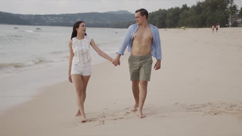 Romantic Couple Walking Hand in Hand on Beach