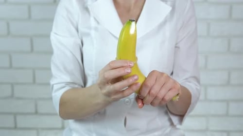 Woman Demonstrates Condom Use on Banana