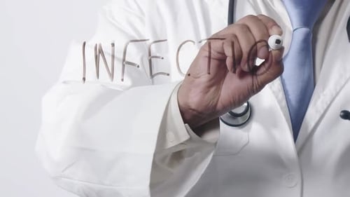 Doctor Writes the Word Infection on Clear Surface