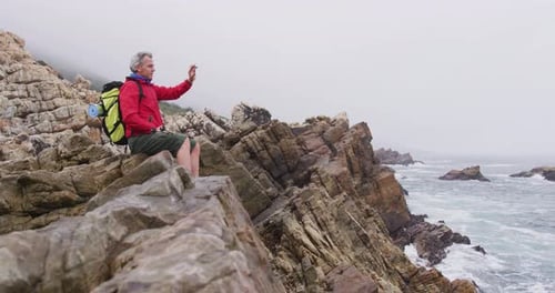 Hiker Resting Along the Rocky Coastline