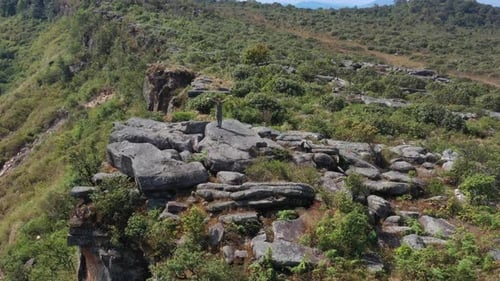 Drone view Young hiking woman standing on rocky peak