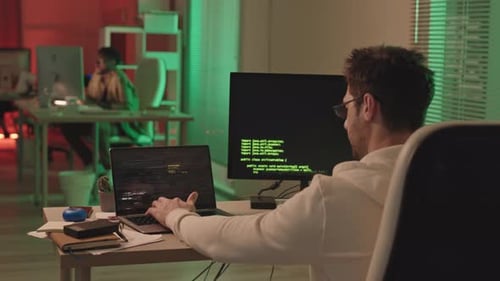 Programmer Working on Code in an Office at Night