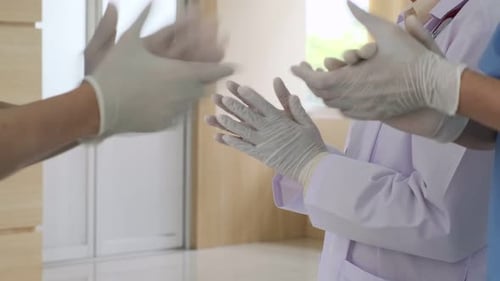 Medical Professionals Clapping with Surgical Gloves On