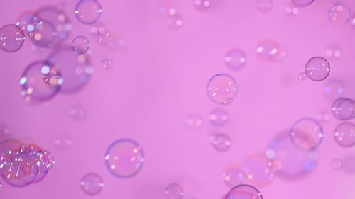 Blue and Clear Soap Bubbles on Light Pink, Background, Slow Motion