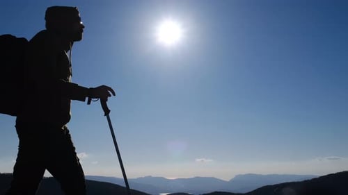 Hiker Silhouette on Mountain Peak with Backpack