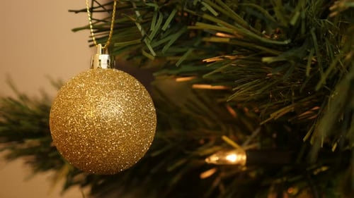 Gold Christmas Ornament Hanging on Green Tree