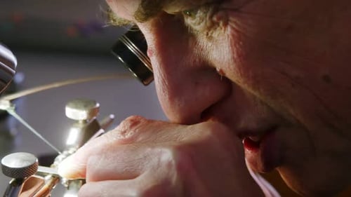 Close-up of horologist using a machine