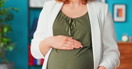 Pregnant Woman Holding Her Belly Indoors