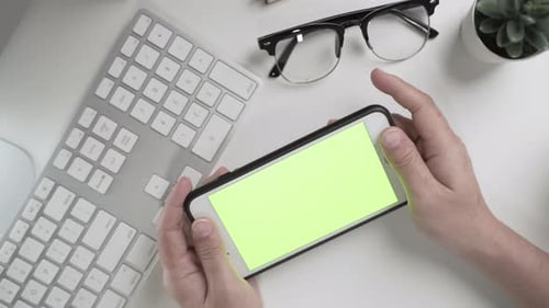 Businesswoman 's hands working and touch screen the green screen on smartphone