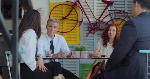 Colleagues Discussing Business Over Drinks at Workplace