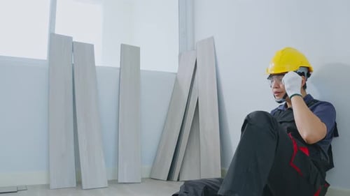 Asian Construction worker male feel tired and lying on floor after work to renovate house.