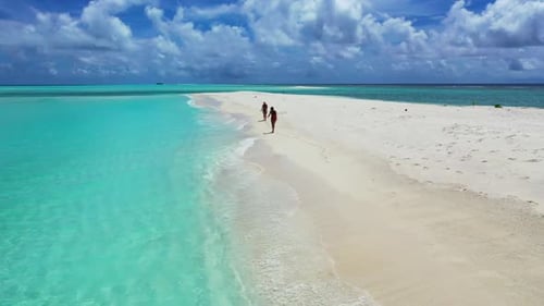 Girls happy together on idyllic coast beach holiday by shallow lagoon with white sand background of