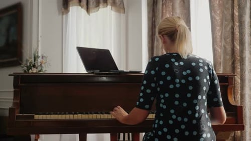 Woman Plays Piano with Laptop in Home