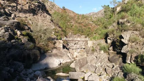 Casal sênior na ponte de madeira sobre as rochas do rio
