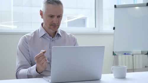 Mature Man Working on Laptop, Celebrates Success