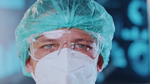 Doctor in Medical Cap, Protective Mask and Goggles Before a Shift in a Hospital