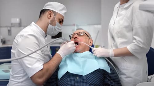 Professional Medical Personnel Working with Elderly Patient at Clinic