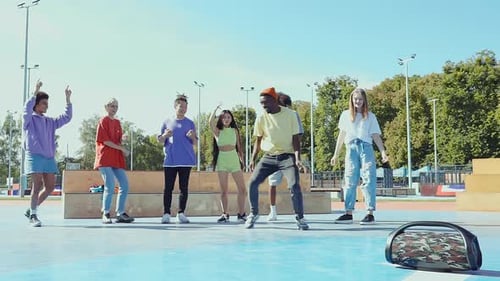 Energetic Young Adults Dancing Together Outdoors
