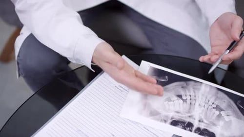 Doctor Explains Dental X-Ray to Patient in Clinic