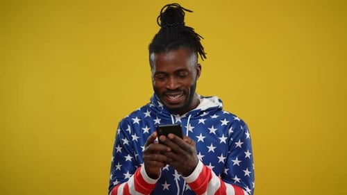 Smiling Man Using Mobile Phone in Studio