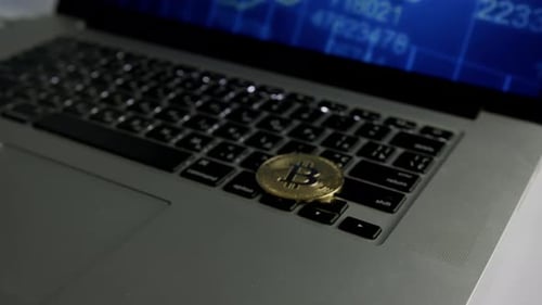 Bitcoin Coin Lying on Laptop Keyboard