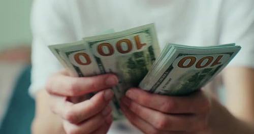 Hands Counting Stack of One Hundred Dollar Bills