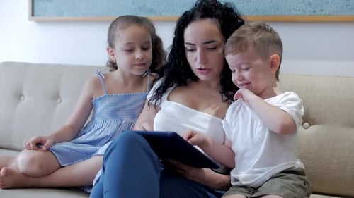 Happy Family Using Tablet Together on Couch