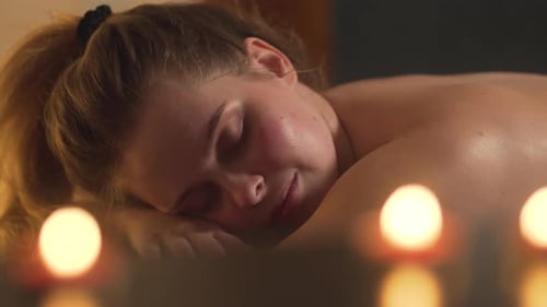Woman Relaxing with a Back Massage and Candles