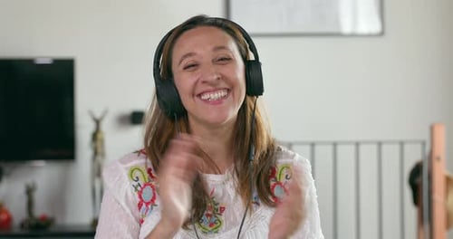 Woman with Headphones Laughs and Claps