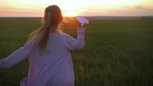 Little Girl Running with Paper Airplane at Sunset