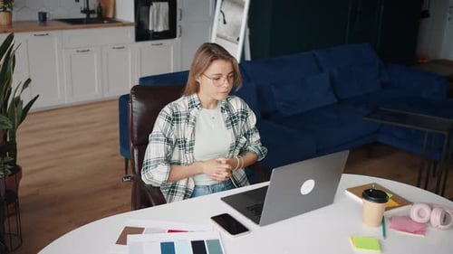 Positive junge Dame in Brillen Videokonferenzen mit potenziellem Arbeitgeber per Laptop sprechen