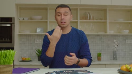 Hombre positivo con pérdida auditiva hablando con lenguaje de señas durante una videollamada