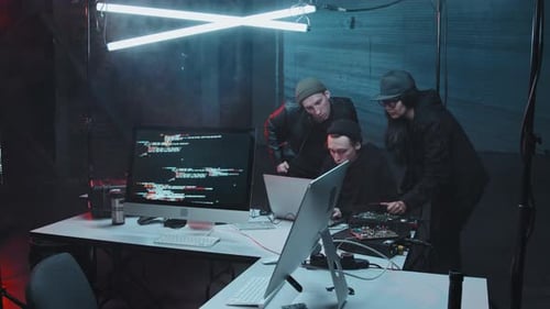 Três hackers conversando e usando o laptop em Dark Hideout