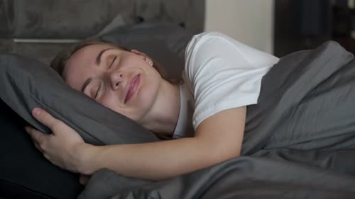 Woman Sleeping Comfortably in Bed at Home