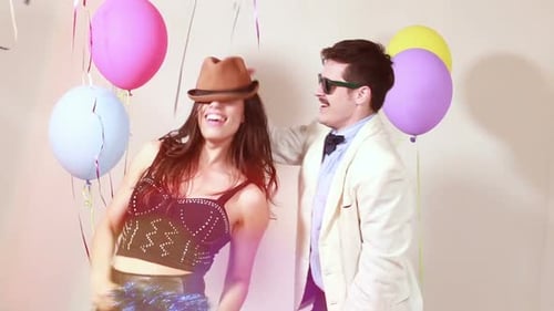 Slow motion of woman and man having awesome time dancing in photo booth