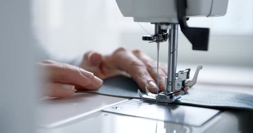 A seamstress works on a sewing machine. Needle and thread in slow motion. 4k