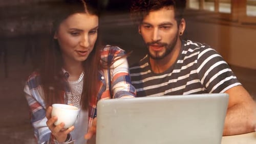 Couple Looking at Laptop in Cafe