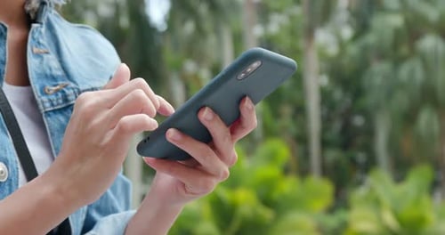 Woman use of mobile phone in city park