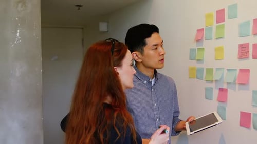 Business executives discussing over sticky notes