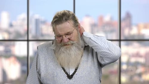 Senior Man Rubbing Neck With Hand