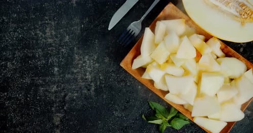 Frische Melonenscheiben auf einem Holzteller mit einem kühlen Dampf.