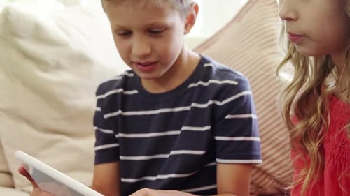 Children Playing on Tablet Device at Home